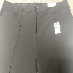 Black dress pants zippers in front of legs at the bottom.